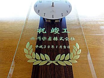 「祝竣工 ○○株式会社」を彫刻した、お取引先の新社屋竣工祝い用の名入れ掛け時計
