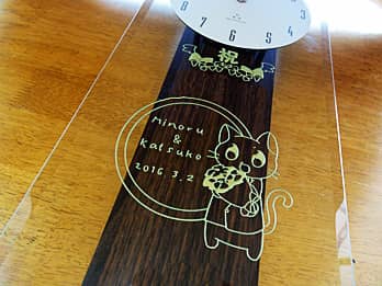 ネコのイラストを前面ガラスに彫刻した、出産祝いの贈り物用の掛け時計