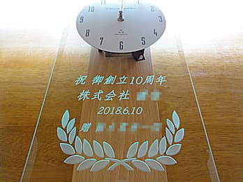 「祝 御創立10周年、株式会社○○、贈 ○○」を前面ガラスに彫刻した、お取引先への周年祝い用の掛け時計