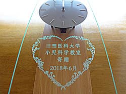 「○○医科大学寄贈」を前面ガラスに彫刻した、開院祝い用の掛け時計