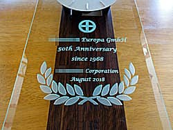 「会社名とマーク、50th anniversary、贈り主の会社名」を前面ガラスに彫刻した、お取引先の創立50周年祝い用の掛け時計