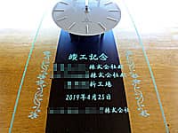 「竣工記念 ○○株式会社 ○○新工場」を彫刻した、新工場の竣工祝い用の掛け時計
