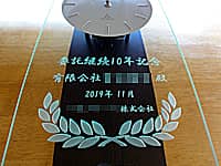 業務委託継続の表彰用の掛け時計（委託継続10年記念、有限会社○○殿、○○株式会社を前面ガラスに彫刻）