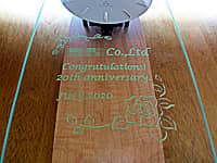 会社の20周年祝い用の掛け時計（○○ Co., Ltd. Congratulations! 20th anniversaryを、掛け時計の前面ガラスに彫刻）