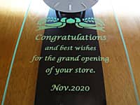 開店祝い用の掛け時計（Congratulations and best wishes for the grand opening of your store. Nov.2020を、掛け時計の前面ガラスに彫刻）