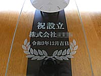 「祝設立 株式会社○○ 令和3年12月吉日」を前面ガラスに彫刻した、株式会社設立祝い用の掛け時計