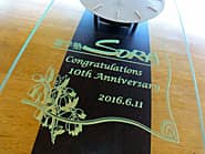 「Congratulations! 10th anniversary」「ロゴマーク」を前面ガラスに彫刻した、進学塾の10周年祝い用の掛け時計