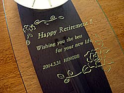 「Happy retirement、日付、会社名」を前面ガラスに彫刻した、上司への定年退職のプレゼント用の掛け時計
