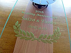 「50th wedding anniversary、両親の名前、日付」を前面ガラスに彫刻した、両親の金婚式の贈り物用の掛け時計