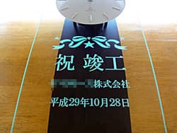 「祝竣工、○○株式会社、日付」を前面ガラスに彫刻した、お取引先の竣工祝い用の掛け時計