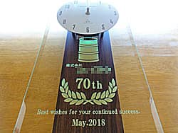 「70th、会社名、日付」を前面ガラスに彫刻した、お取引先の70周年祝い用の掛け時計