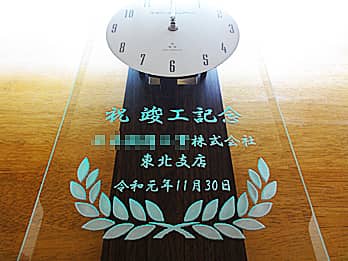 「お祝いメッセージ、贈る相手の会社名、竣工日の日付」を前面ガラスに彫刻した、竣工祝い用の掛け時計