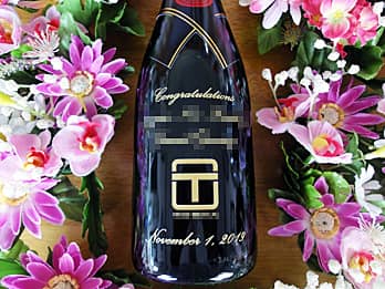 「会社のロゴマーク、お祝いメッセージ、永年勤続者名、贈呈日の日付」をボトル側面に彫刻した、永年勤続表彰用のシャンパン