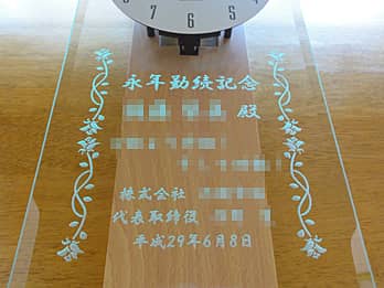 「永年勤続記念 ○○殿、会社名と贈呈者名、表彰日の日付」を前面ガラスに彫刻した、永年勤続表彰用の掛け時計