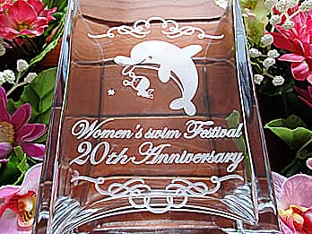「20th anniversary、ロゴマーク」を側面に彫刻した、スイミングスクールの周年祝い用のフラワーベース