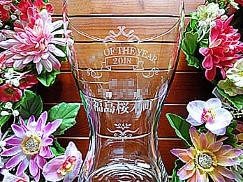 お客さまがデザインしたオリジナル図案を側面に彫刻した、表彰記念品用のガラス花瓶