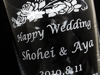 結婚祝い用のフラワーベース側面に彫刻した、「Happy Wedding、新郎と新婦の名前」のクローズアップ画像