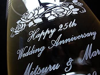 結婚記念日祝い用のフラワーベースの側面に彫刻した、「Happy 25th wedding anniversary、奥さまと旦那様の名前」のクローズアップ画像