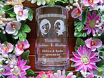 新郎新婦の似顔絵と名前を側面に彫刻した、結婚祝い用のガラス花器
