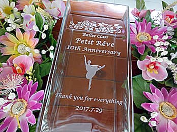 「バレエ教室名、10th anniversary、バレリーナのイラスト」を彫刻した、バレエ教室の10周年祝い用のフラワーベース