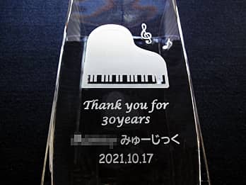 「ピアノと音符のイラスト、Thank you for 30years 、○○みゅーじっく、日付」を側面に彫刻した、音楽教室の周年祝い用のフラワーベース