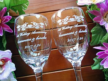 「1st wedding anniversary、奥さまと旦那様の名前」を側面に彫刻した、結婚記念日の贈り物用のペアのワイングラス