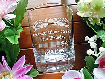 「Congratulations on your 60th birthday、○○さん」を側面に彫刻した、還暦祝い用の名入れグラス