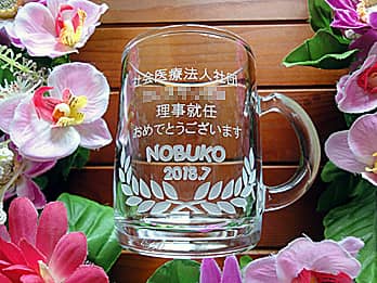 「理事就任おめでとうございます、名前、病院名」を側面に彫刻した、就任祝い用のガラス製マグカップ