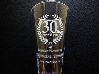 「30th ANNIVERSARY、永年勤続者の名前、表彰日の日付」を側面に彫刻した、勤続30年表彰用のグラス