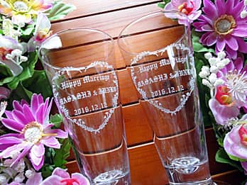 「お祝いメッセージ、贈る相手の名前、日付」を側面に彫刻したペアのピルスナーグラス