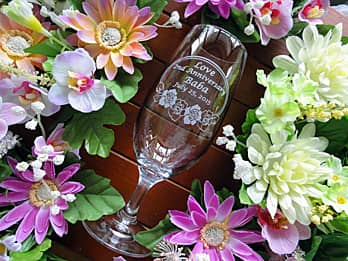 「2nd anniversary、常連客の名前」「バラの花のイラスト」を側面に彫刻した、スナックの周年記念品用のピルスナーグラス