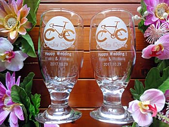 「自転車サークルのマーク、Happy wedding、新郎と新婦の名前」を側面に彫刻した、結婚祝い用のペアのビアグラス