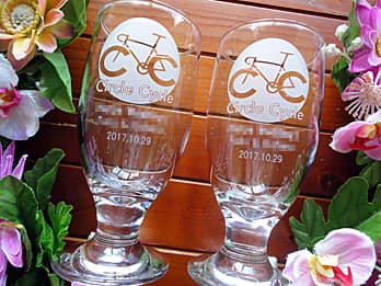 「自転車のイラスト、○○賞、受賞者の名前」を側面に彫刻した、自転車競技の賞品用のビアグラス