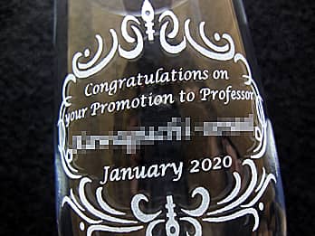 教授就任祝い用のグラス側面に彫刻した、「お祝いメッセージ（Congratulations on your promotion to professor）、贈る相手の名前、日付」のクローズアップ画像