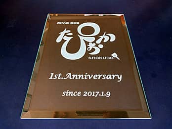 「ロゴマーク」「1st anniversary」を彫刻した、お店の周年祝い用のガラス盾