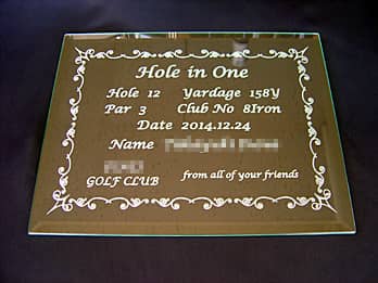 「Hole in one、達成日、達成者の名前」を彫刻した、ホールインワンの記念品用のガラス盾