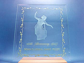 「○○賞、主催団体の名前、インド舞踊のイラスト」を彫刻した、インド舞踊発表会の賞品用のガラス盾