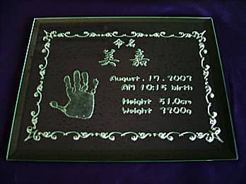 「赤ちゃんの名前、出生時の身長と体重、赤ちゃんの手形」を彫刻した、出産祝い用のガラス盾