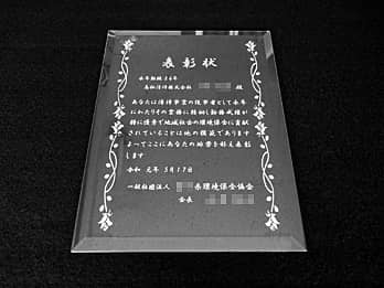 受賞者名と表彰文を彫刻したガラス盾