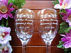 「1st wedding anniversary、奥さまと旦那様の名前、日付」を彫刻した、結婚記念日の贈り物用のペアのワイングラス