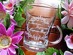 「Thank you for your visit、店名、日付」を側面に彫刻した、お客様へ配付する周年記念品用のガラス製ティーカップ