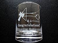 けん玉競技の賞品用のグラス（けん玉のイラストと、Congratulations、受賞者の名前、日付をロックグラスの側面に彫刻）