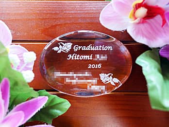 「Graduation、卒業する生徒の名前、卒業年度、学校名」を彫刻した、卒業記念品用のガラス製ペーパーウェイト