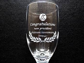 「会社のマーク、Congratulations、new president、新社長の名前、就任日の日付」を側面に彫刻した、社長就任祝い用のグラス