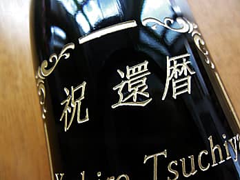 還暦祝い用のワインの側面に彫刻した、「お祝いメッセージと名前」のクローズアップ画像