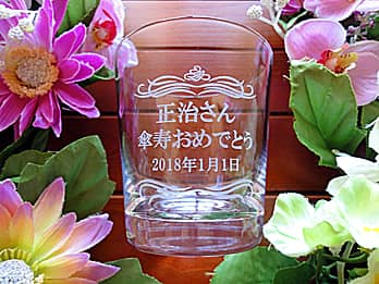 「○○さん 傘寿おめでとう」を側面に彫刻した、傘寿祝い用の名入れロックグラス