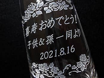 喜寿祝い用のガラス花瓶の側面に彫刻した、「お祝いメッセージ、贈り主の名前、お祝い日の日付」のクローズアップ画像