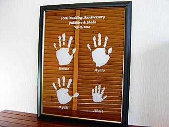 「10th wedding anniversary、旦那様と奥さまの名前、家族全員の手形」を表面に彫刻した、結婚記念日のお祝い品用の鏡