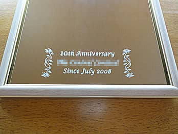 「10th anniversary、会社名」を彫刻した、お取引先へ贈呈する周年祝い用の鏡