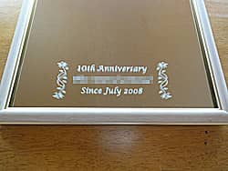 「10th anniversary、お取引先の会社名、since ○○」を彫刻した、お取引先へ贈呈する周年祝い用の鏡